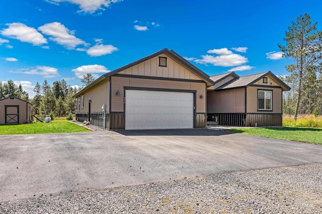 ranch-style house featuring aphalt driveway, a storage shed, an outdoor structure, a garage, and a front yard
