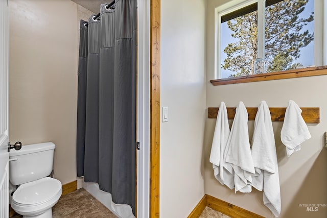 full bath featuring baseboards, a shower with curtain, and toilet
