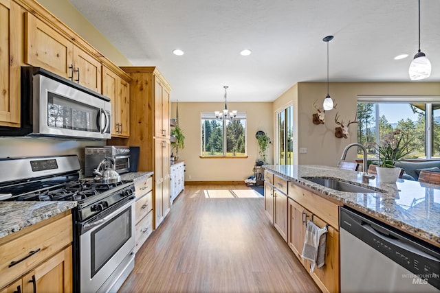 kitchen featuring a sink, stainless steel appliances, light wood-style flooring, and a healthy amount of sunlight