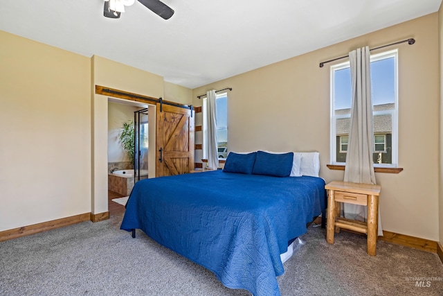 bedroom featuring a barn door, carpet floors, baseboards, and multiple windows
