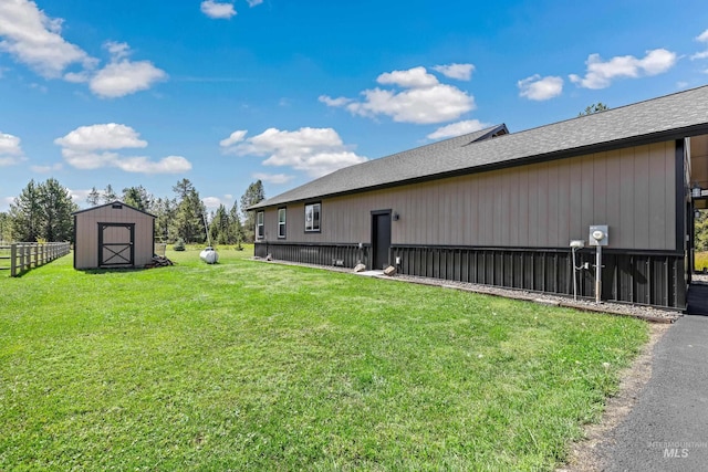 exterior space with a yard, fence, an outbuilding, and a shed