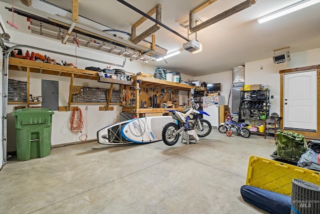 garage featuring a workshop area, electric panel, and a garage door opener