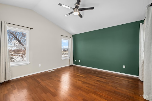 unfurnished bedroom featuring lofted ceiling, dark wood-type flooring, and multiple windows