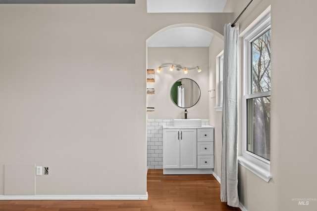 bathroom with baseboards, wood finished floors, and vanity