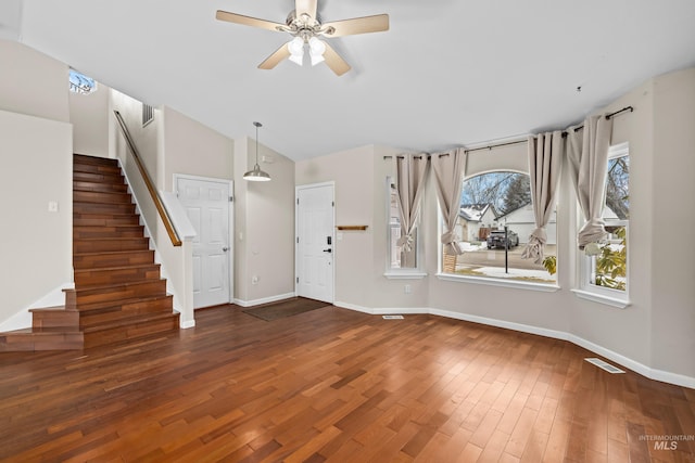 foyer entrance featuring a ceiling fan, baseboards, vaulted ceiling, stairs, and dark wood-style floors