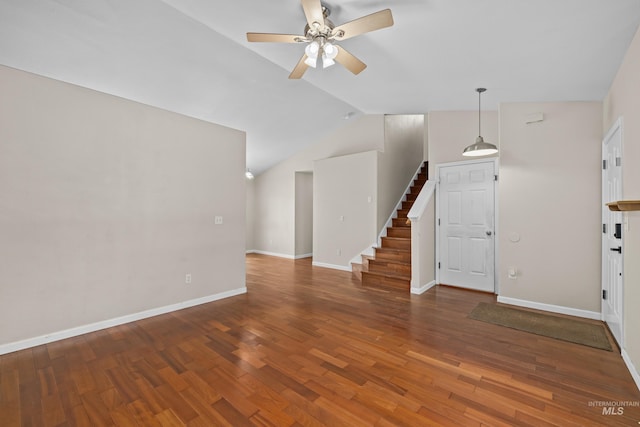 interior space featuring baseboards, a ceiling fan, dark wood-style floors, stairs, and vaulted ceiling