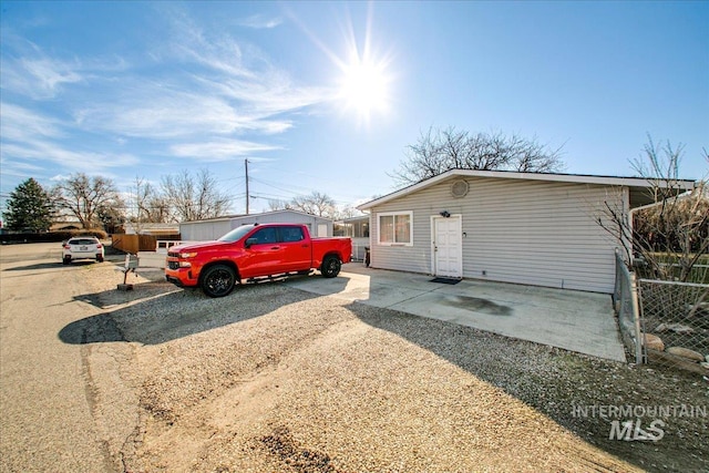 view of front facade featuring driveway and fence