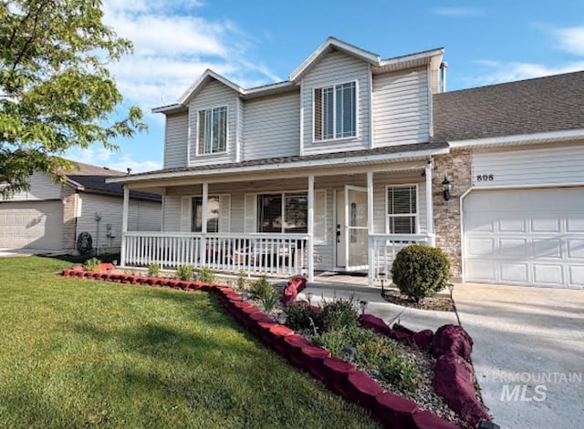view of front of house with concrete driveway, a front yard, a porch, and an attached garage