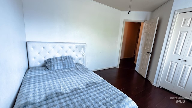bedroom with baseboards and wood finished floors