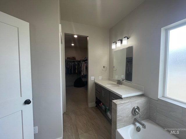 1111 Thunder Mountain St, Kimberly, ID 83341 - bathroom with vanity, a walk in closet, a garden tub, and marble look tiles