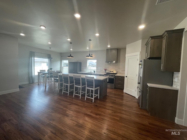 1111 Thunder Mountain St, Kimberly, ID 83341 - kitchen featuring stainless steel appliances, a large island, wall chimney exhaust hood, backsplash, and a breakfast bar area