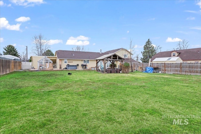 view of yard with a gazebo, an outbuilding, and a fenced backyard