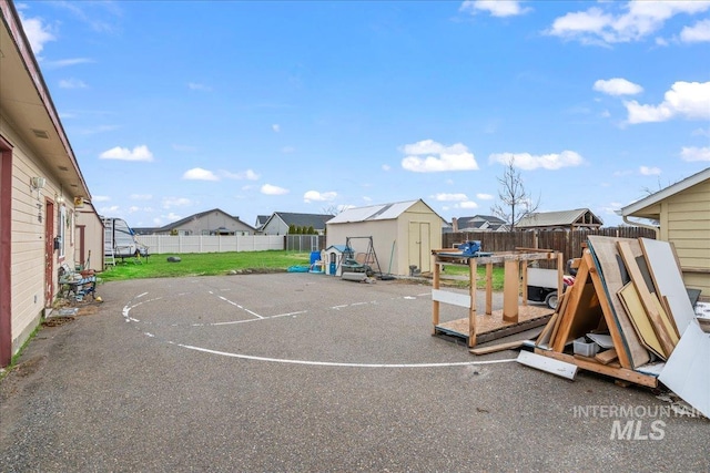 exterior space featuring a residential view, a storage shed, a fenced backyard, and an outdoor structure