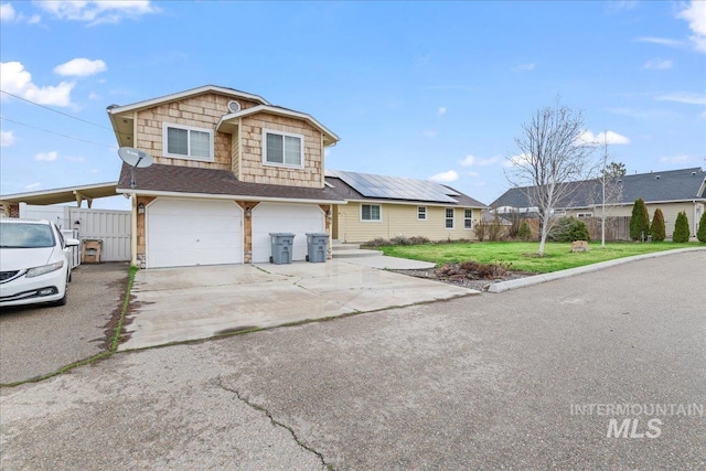 view of front of property with solar panels, a front lawn, fence, driveway, and an attached garage