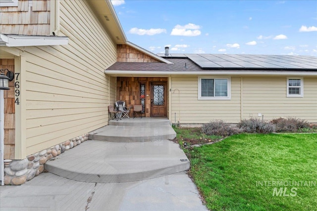 entrance to property with a lawn and solar panels