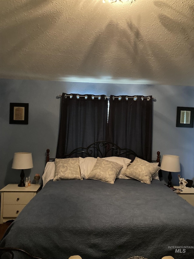 bedroom featuring carpet flooring and a textured ceiling