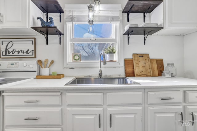 kitchen featuring white cabinets, a sink, ventilation hood, light countertops, and white range with electric cooktop