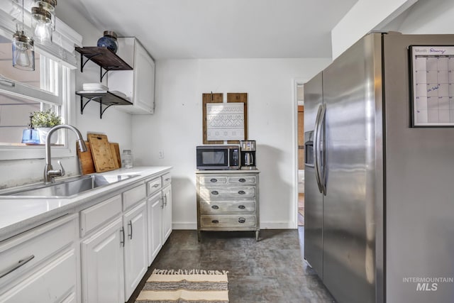 kitchen featuring stainless steel appliances, a sink, white cabinets, light countertops, and open shelves