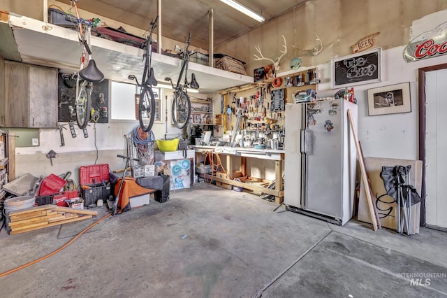 garage featuring freestanding refrigerator and a workshop area