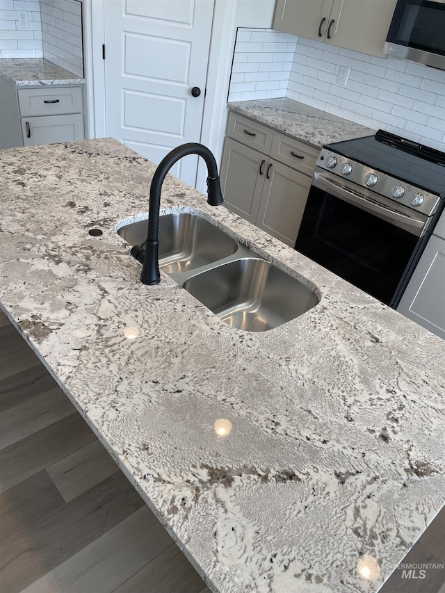 484 Hope Ave, Twin Falls, ID 83301 - kitchen with appliances with stainless steel finishes, a sink, light stone counters, and wood finished floors