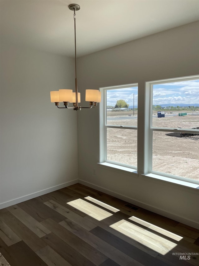 484 Hope Ave, Twin Falls, ID 83301 - spare room with a chandelier, baseboards, and wood finished floors