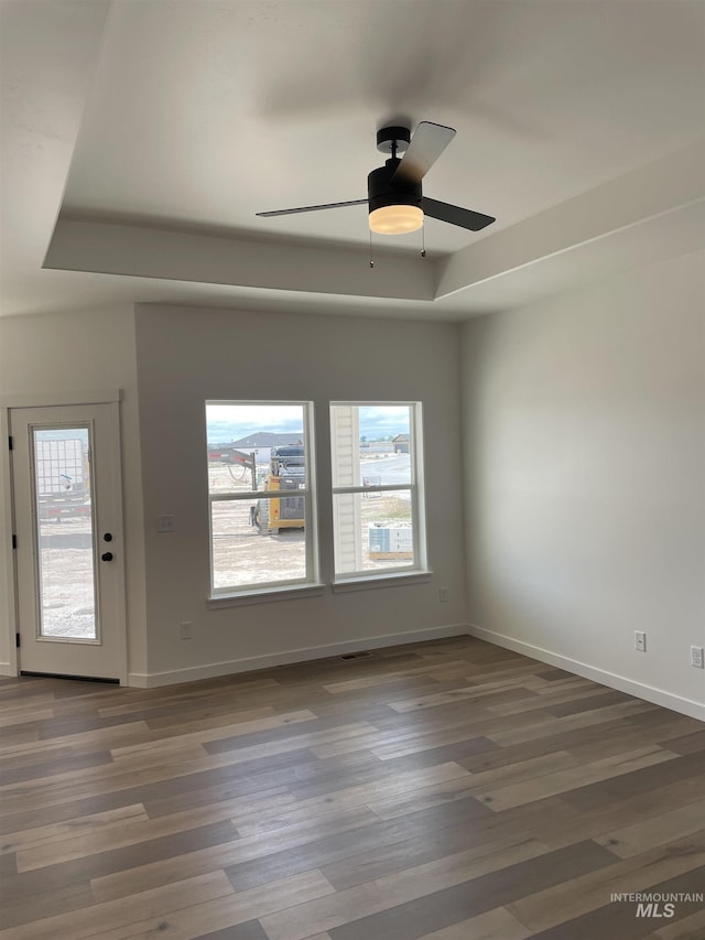 484 Hope Ave, Twin Falls, ID 83301 - unfurnished room featuring baseboards, wood finished floors, a raised ceiling, and ceiling fan