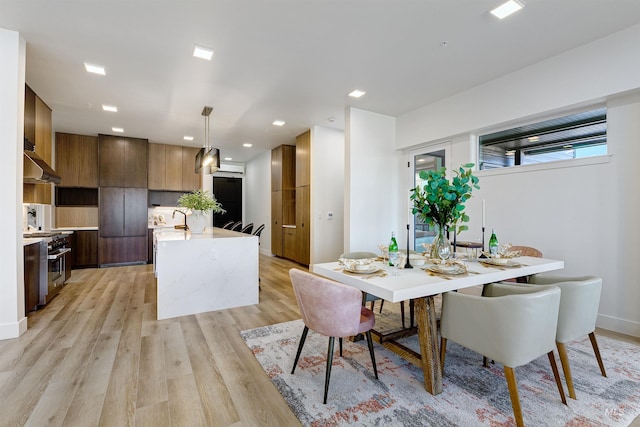 dining space featuring light hardwood / wood-style flooring and sink