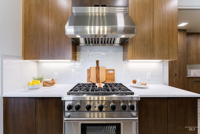 kitchen with exhaust hood, backsplash, and high end stainless steel range oven