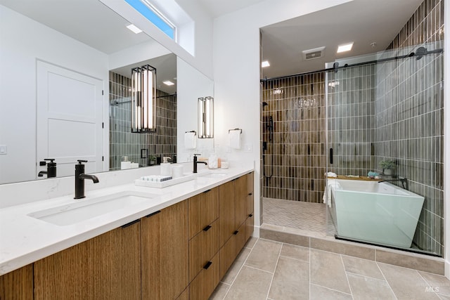 bathroom with vanity, tile walls, tile patterned floors, and shower with separate bathtub