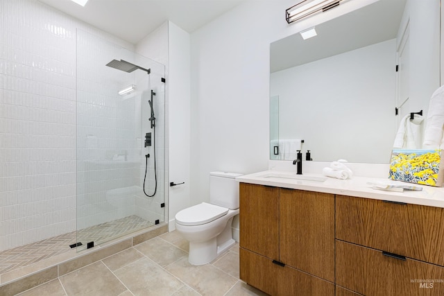 bathroom with toilet, vanity, tile patterned floors, and tiled shower