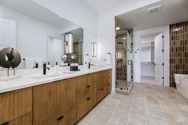 bathroom featuring tile patterned flooring, a shower with door, and vanity