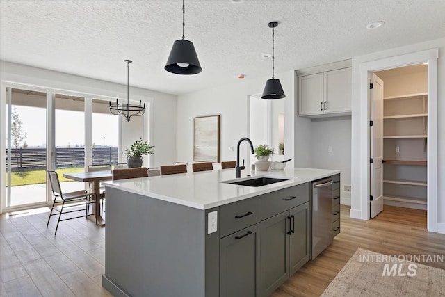 8447 W Happy Day Dr, Meridian, ID 83646 - kitchen with a sink, gray cabinets, light wood-type flooring, stainless steel dishwasher, and light countertops