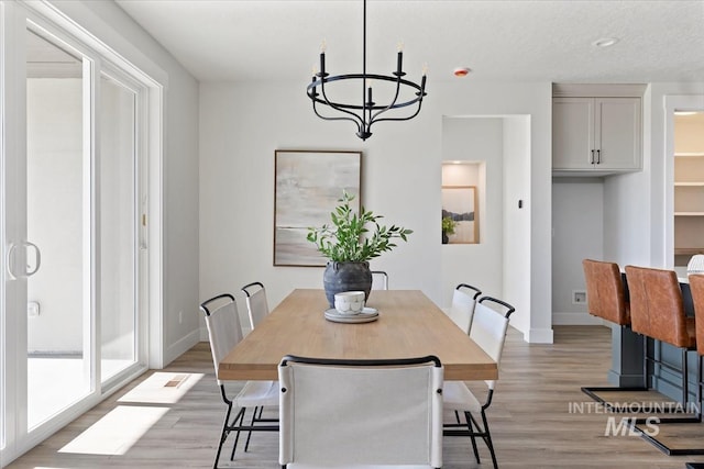 8447 W Happy Day Dr, Meridian, ID 83646 - dining room with a chandelier, light wood-style flooring, and baseboards