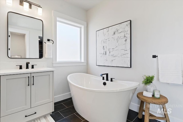 8447 W Happy Day Dr, Meridian, ID 83646 - full bathroom featuring vanity, a freestanding bath, baseboards, and tile patterned flooring