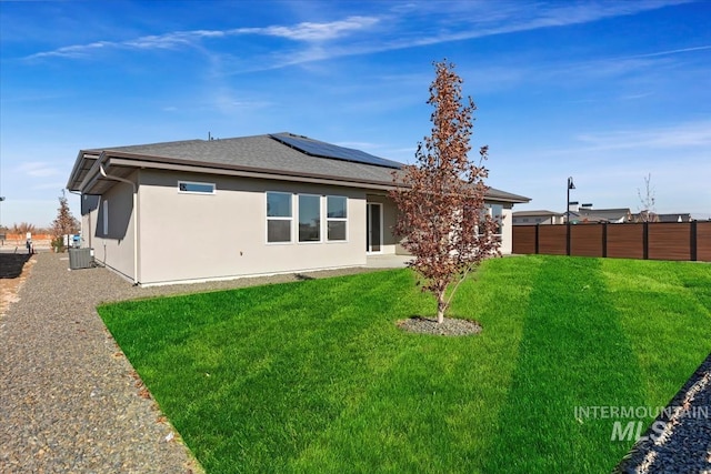 8447 W Happy Day Dr, Meridian, ID 83646 - rear view of property featuring central air condition unit, roof mounted solar panels, stucco siding, and a shingled roof