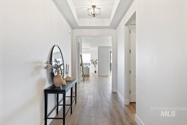 8447 W Happy Day Dr, Meridian, ID 83646 - corridor with wood finished floors, a chandelier, and baseboards
