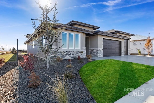 8447 W Happy Day Dr, Meridian, ID 83646 - view of front of home featuring concrete driveway, an attached garage, stone siding, a front lawn, and stucco siding