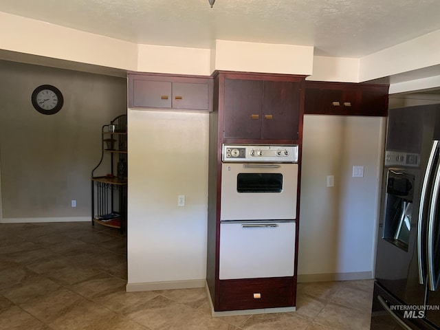 2409 S Ohio, Caldwell, ID 83605 - kitchen featuring fridge with ice dispenser, white double oven, baseboards, and light tile patterned flooring