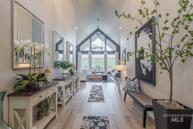 interior space featuring wood finished floors, high vaulted ceiling, and ceiling fan