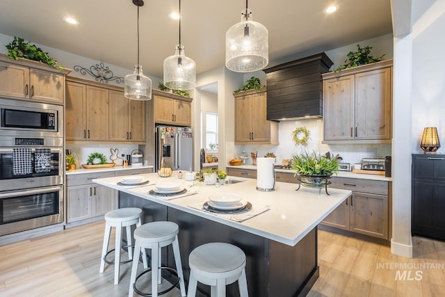 kitchen featuring custom exhaust hood, a sink, stainless steel appliances, light countertops, and backsplash