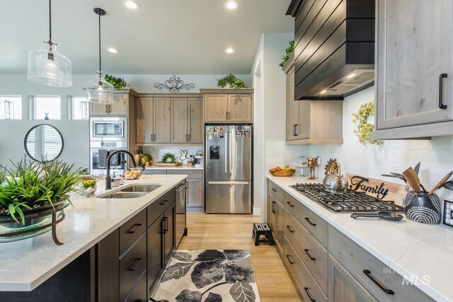 kitchen featuring tasteful backsplash, a sink, stainless steel appliances, light wood-style flooring, and custom range hood