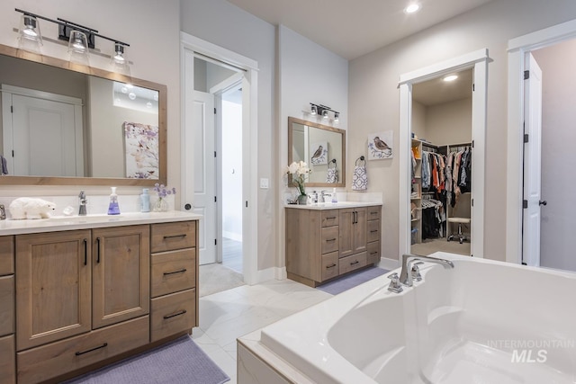 full bath with recessed lighting, a sink, a walk in closet, two vanities, and a garden tub