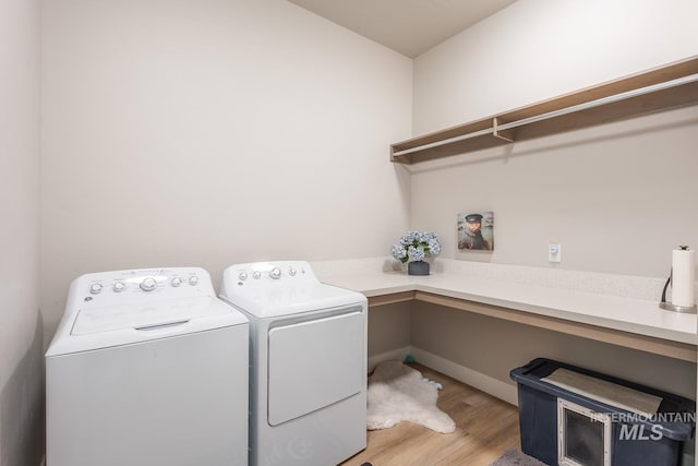 laundry room featuring washing machine and clothes dryer, light wood-style floors, and laundry area