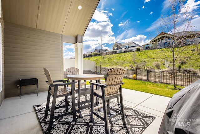 view of patio with a fenced backyard, a residential view, and outdoor dining space