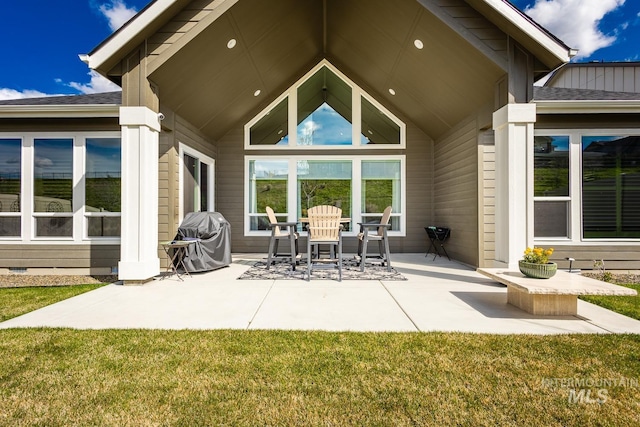 back of house featuring a lawn, outdoor dining area, and a patio