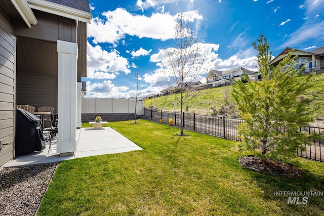 view of yard with a fenced backyard, a residential view, and a patio