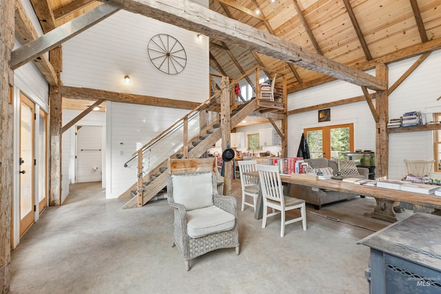 living room with wood walls, wooden ceiling, high vaulted ceiling, french doors, and beamed ceiling