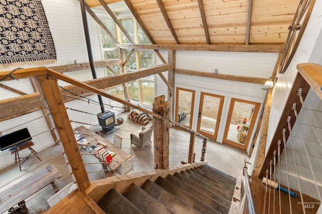 stairs with beam ceiling, wooden ceiling, and high vaulted ceiling