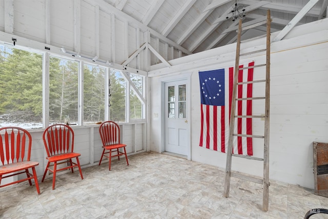 sunroom featuring vaulted ceiling with beams and a wealth of natural light