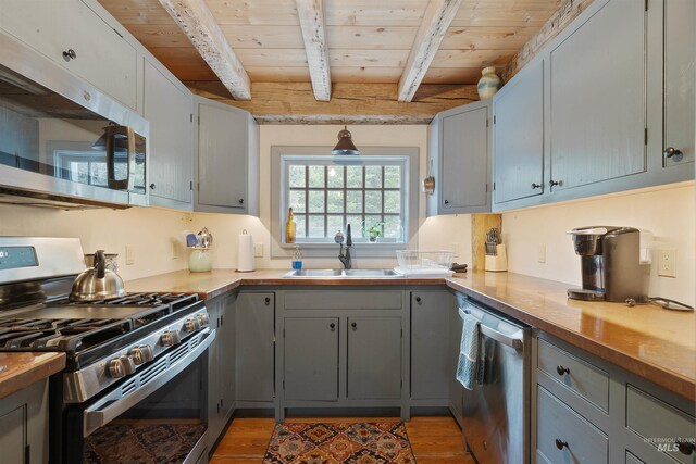 kitchen featuring beamed ceiling, sink, wood ceiling, and stainless steel appliances